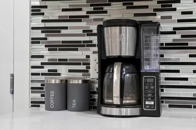 a coffee maker and two cups on a shelf at Modern 2BR Private Suite NW Near Airport & Amazing Shopping! Free Banff Pass, Netflix, Parking! in Calgary