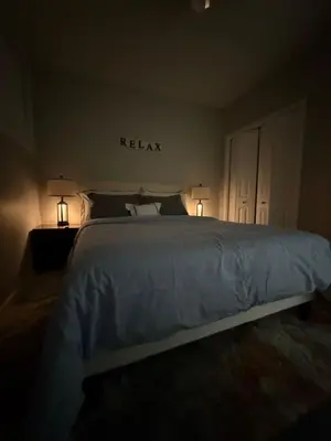a bedroom with a bed with two lamps on it at Almost Heaven - Cozy 2BDRM APT near Heritage Park,Spruce Meadows & Banff-SW Calgary in Calgary