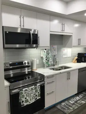 a kitchen with a stove and a microwave at Almost Heaven - Cozy 2BDRM APT near Heritage Park,Spruce Meadows & Banff-SW Calgary in Calgary