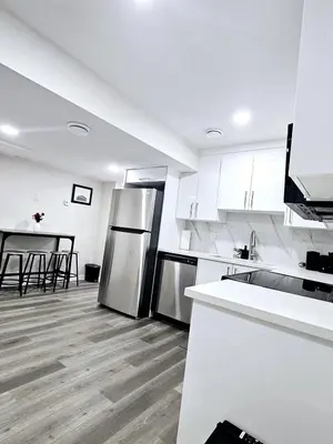 a kitchen with stainless steel appliances and a table at A Cozy Home away from Home in Edmonton