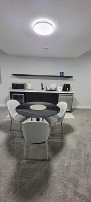 a room with a table and chairs and a kitchen at Cozy 1 bedroom basement suite in Southwest Calgary in Calgary