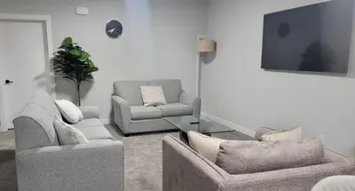 a living room with two chairs and a tv at Cozy 1 bedroom basement suite in Southwest Calgary in Calgary