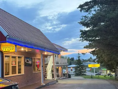 a building with a staircase in front of it at Athabasca Hillside Motel in Athabasca