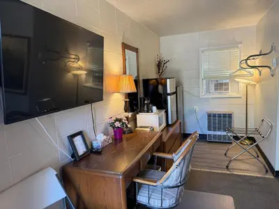 a room with a wooden desk in a room at Athabasca Hillside Motel in Athabasca