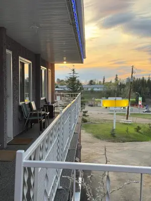 a porch of a house with a white railing at Athabasca Hillside Motel in Athabasca