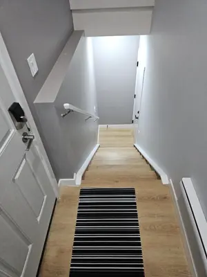 a hallway with a staircase with a black and white rug at Lovely Brand New 2 Bedroom Suite in Calgary in Calgary