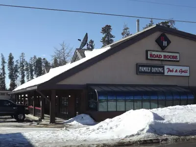 a building with snow on the ground in front of it at Canadas Best Value Inn Whitecourt in Whitecourt