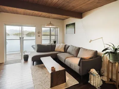 a living room with a couch and a table at Island Vista - Waterfront Condo in Tofino
