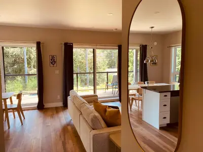 a living room with a couch and a dining room at Haven On The Hill in Port Renfrew