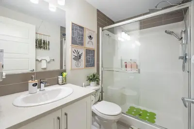 a bathroom with a shower and a toilet and a sink at Tropical Caribbean-Themed Cozy Getaway - King Bed-Free Parking in Calgary