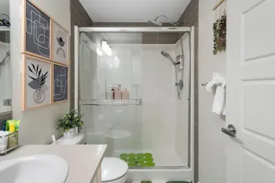 a bathroom with a shower with a toilet and a sink at Tropical Caribbean-Themed Cozy Getaway - King Bed-Free Parking in Calgary