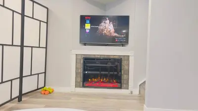 a living room with a fireplace with a flat screen tv at Calgary Airport Stay Private Suite 1Bed in Calgary