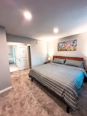 a bedroom with a bed and a painting on the wall at Modern Downtown Stay in Yellowknife