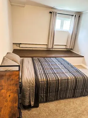 a bedroom with a large bed with a window at Modern Downtown Stay in Yellowknife