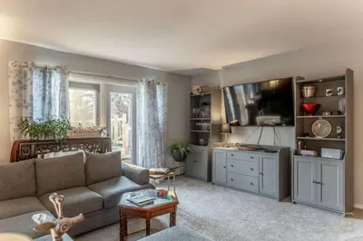 a living room with a couch and a flat screen tv at Modern Downtown Stay in Yellowknife