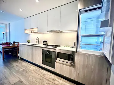a kitchen with stainless steel appliances and a table at Fashion 1B1B locates in the heart of Richmond in Richmond