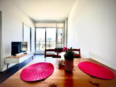 two pink umbrellas on a wooden table in a living room at Stylish 1B1B locates in the heart of Richmond in Richmond