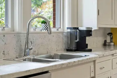 a kitchen counter with a sink and a coffee maker at Historic Treend Residence in the heart of Mission Calgary in Calgary