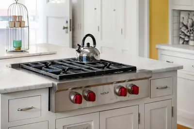 a kitchen with a stove with a tea kettle on it at Historic Treend Residence in the heart of Mission Calgary in Calgary