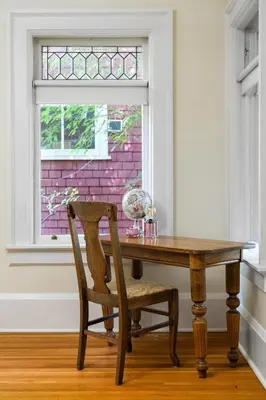 a wooden table with a chair and a window at Historic Treend Residence in the heart of Mission Calgary in Calgary