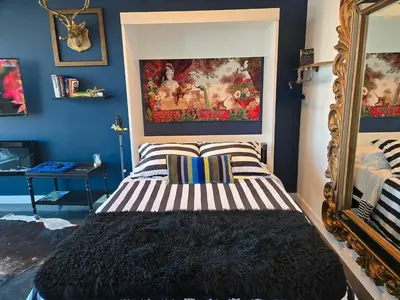 a bedroom with a bed with a painting on the wall at Boutique Studio City Views, Patio, Fireplace Voglio Bene in Calgary