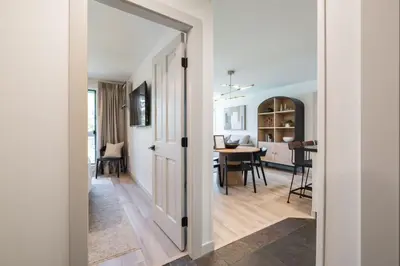 a hallway with a door leading to a dining room at Greystone Lodge by Outpost Whistler in Whistler