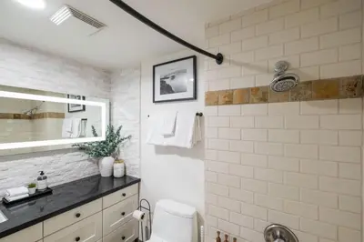 a white bathroom with a sink and a toilet at Greystone Lodge by Outpost Whistler in Whistler