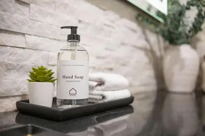 a bottle of hand soap sitting on a table with a plant at Greystone Lodge by Outpost Whistler in Whistler
