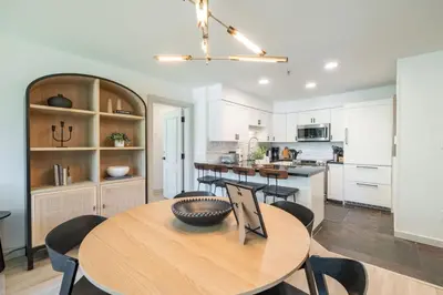 a kitchen and dining room with a wooden table and chairs at Greystone Lodge by Outpost Whistler in Whistler
