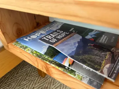 a magazine sitting on top of a wooden table at Posada Nordica - a chic, tranquil mountainview suite in Hope