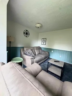 a living room with a couch and a table at Blue Cypress Suite- Downtown Tofino in Tofino