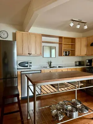 a kitchen with a table and some pots and pans at Blue Cypress Suite- Downtown Tofino in Tofino
