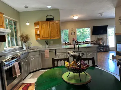 a kitchen with a table with a bowl of fruit on it at Golden Ears Serenity in Maple Ridge District Municipality