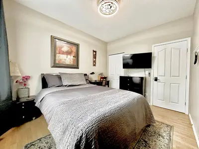 a bedroom with a bed and a flat screen tv at Golden Ears Serenity in Maple Ridge District Municipality