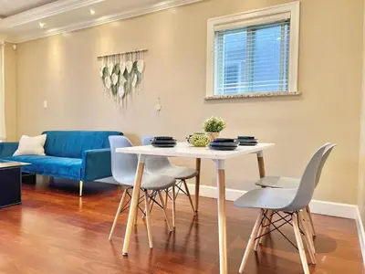a dining room and living room with a table and chairs at Central & Comfy 1B1B in Vancouver
