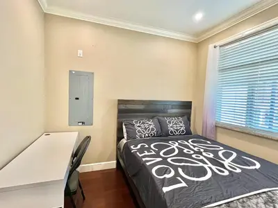 a bedroom with a bed and a desk and a window at Central & Comfy 1B1B in Vancouver