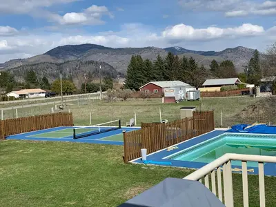 two tennis courts in a field with mountains in the background at Beach Bed and Breakfast in Grand Forks