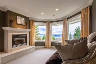 a living room with a fireplace and a couch at Luxury 5BR Villa, Gym, Theater & Ocean Views in West Vancouver