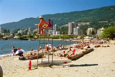 a crowd of people on a beach with a life guard at Luxury 5BR Villa, Gym, Theater & Ocean Views in West Vancouver