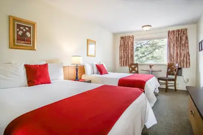 a hotel room with two beds and a window at Gables Motel in Radium Hot Springs