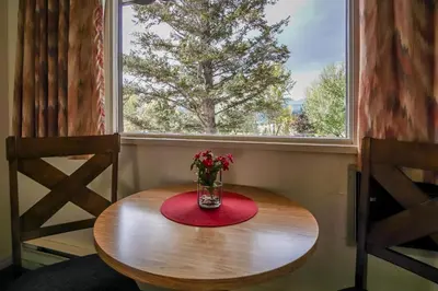 a table with a vase of flowers sitting in front of a window at Gables Motel in Radium Hot Springs