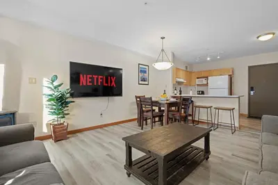a living room with a couch and a table at Heated Outdoor Pool & Tubs 9 Guests in Canmore