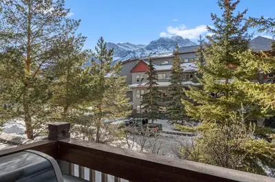 a view from the balcony of a hotel with mountains at Heated Outdoor Pool & Tubs 9 Guests in Canmore