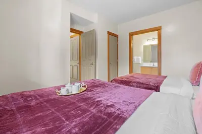 two beds in a room with a tray of coffee cups at Heated Outdoor Pool & Tubs 9 Guests in Canmore