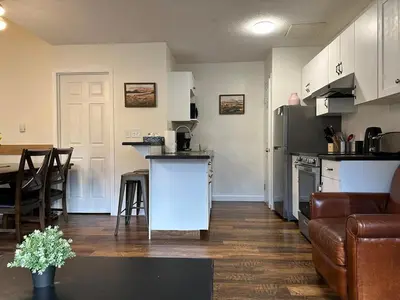 a kitchen and living room with a couch and a table at Banff Boundary Lodge Mountain View 2Brms 3xAC Townhouse in Canmore