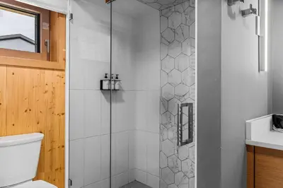 a shower with a glass door in a bathroom at Alps #201- LEED Gold Certified in Canmore