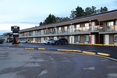 a building with cars parked in a parking lot at Royal Lodge in Edmonton