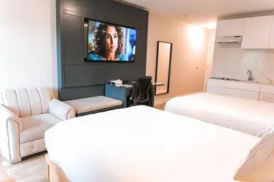a room with two beds and a flat screen tv at Hotel Civilia Lakeside by Civilia Golf Retreat in Clearwater