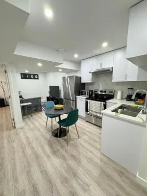 a large kitchen with a table and chairs in it at Modern Comfort in West Edmonton in Edmonton