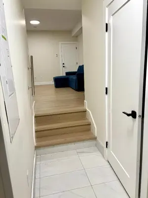 a hallway with stairs leading to a living room at Sunny White Rock 2BR, Steps to Sand, Brand New Stay in White Rock